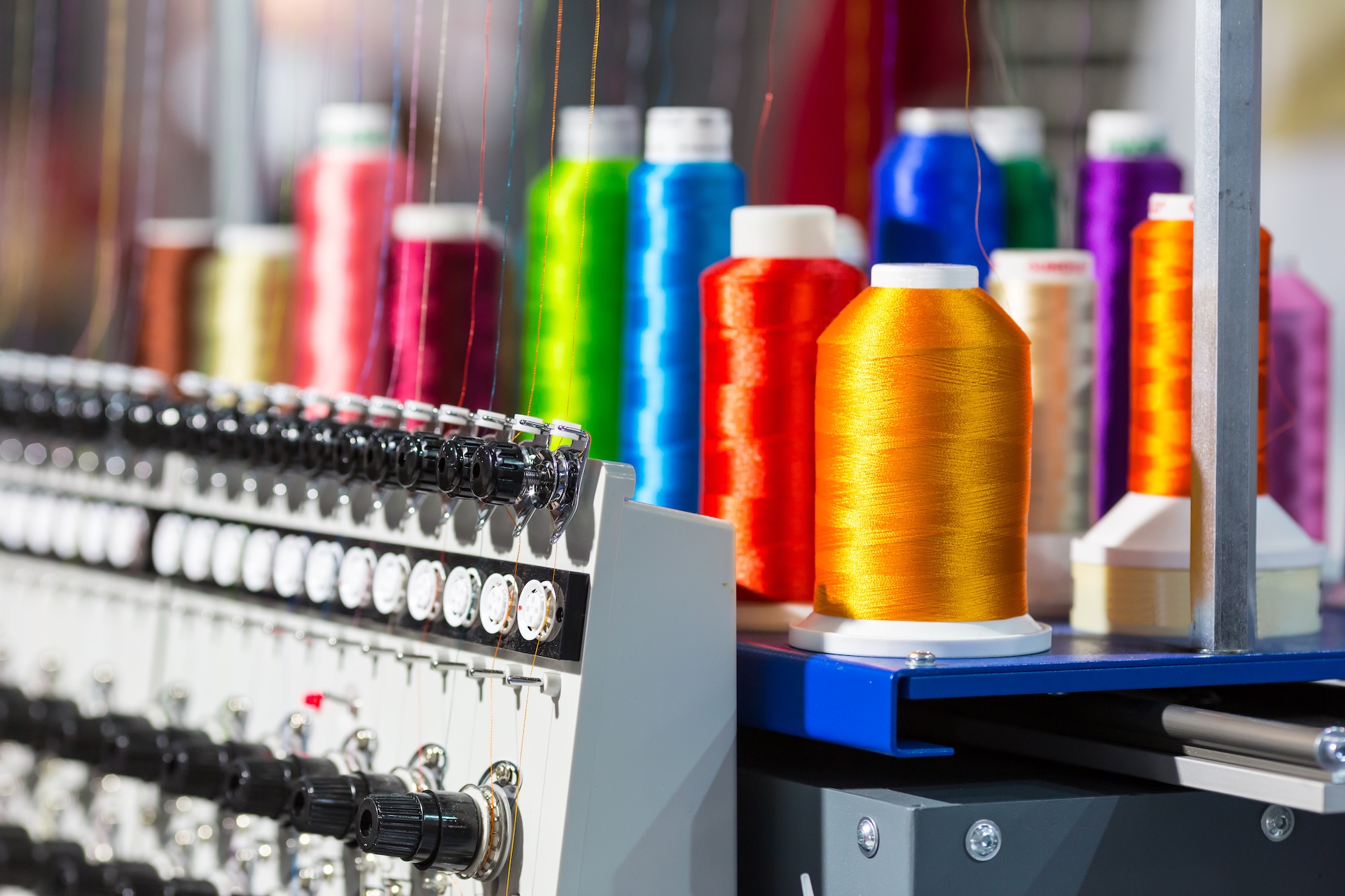 Spools of thread and a commercial custom embroidery machine
