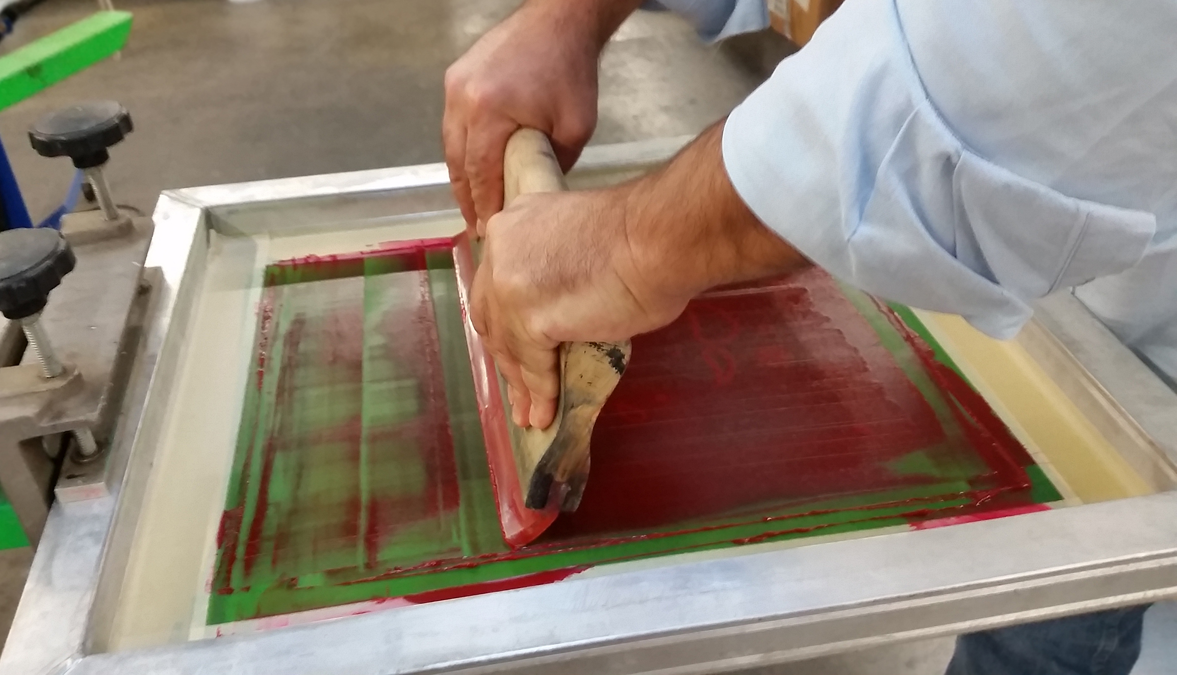 A printer in action demonstrating the essential role of squeegee angle and pressure in achieving crisp, consistent prints. Photo courtesy of International Coatings