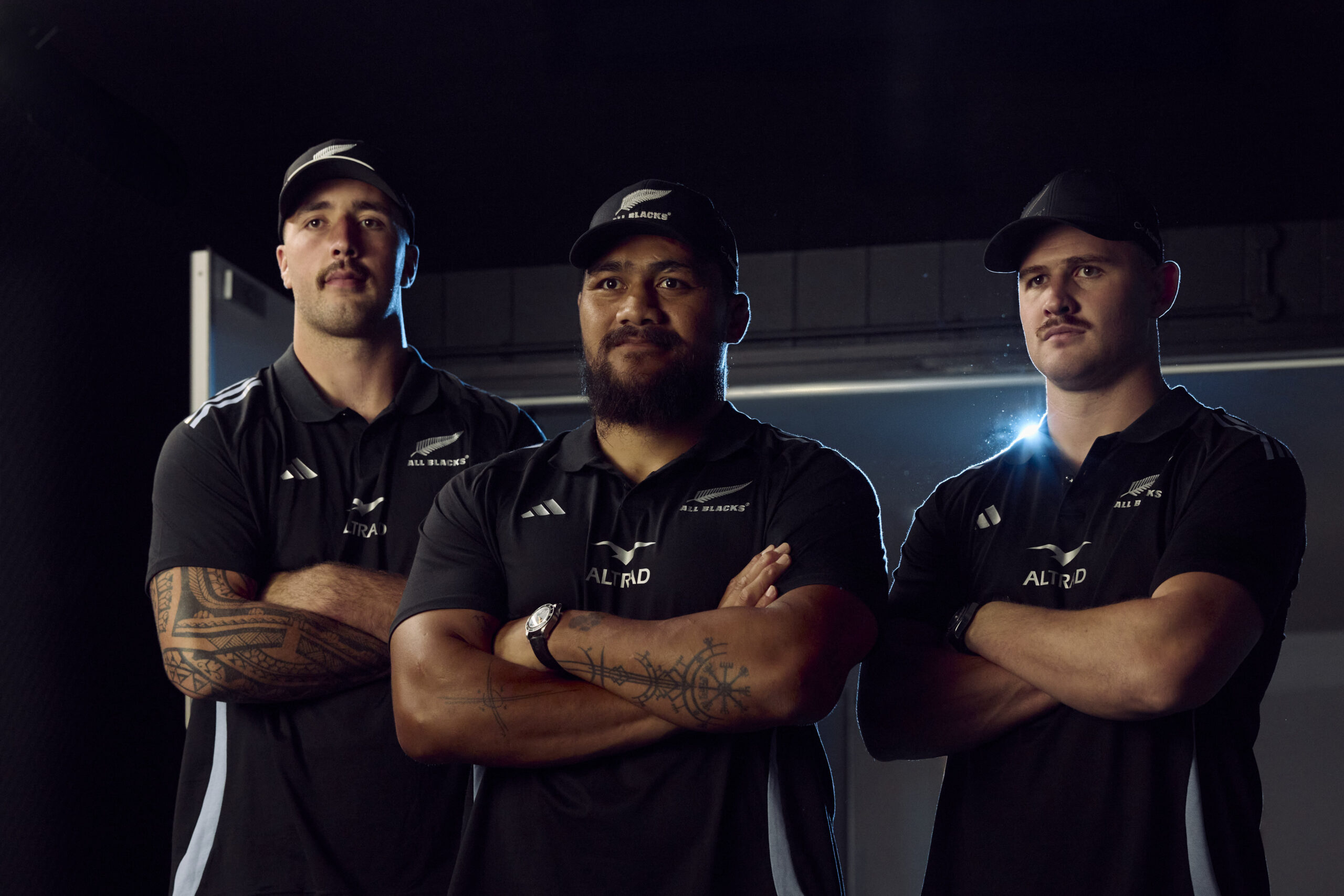 Atlantis Headwear x All Blacks official collaboration — team players and models wearing black caps and beanies from the new collection during a campaign photoshoot.