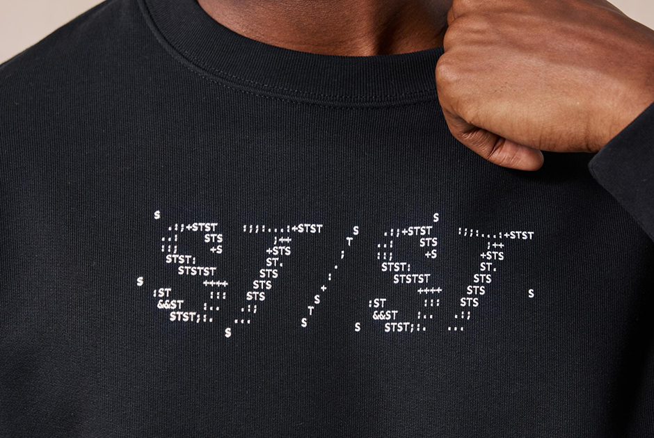 Close-up of a Stanley/Stella black sweatshirt featuring minimalist chest typography, highlighting premium fabric quality and decoration performance.
