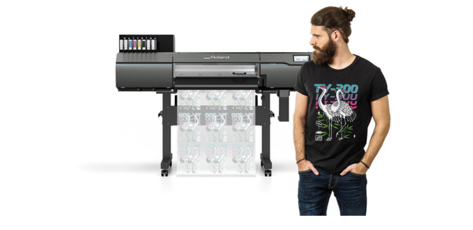 Roland DG TY-300 direct-to-film printer printing DTF transfer film, shown with a finished full-color graphic T-shirt.