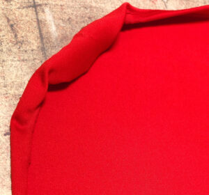 Close-up of heat-damaged polyester fabric showing scorching and glossing caused by excessive curing temperature during screen printing