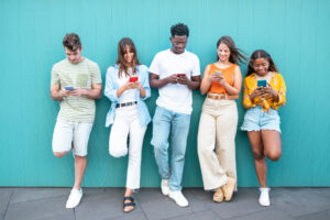 Group of fashion friends watching on their smart mobile phones - Millennial generation z addicted to new technology trends - Concept of youth lifestyle