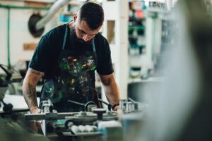 Screen printing apparel shop operator working at a screen-printing press