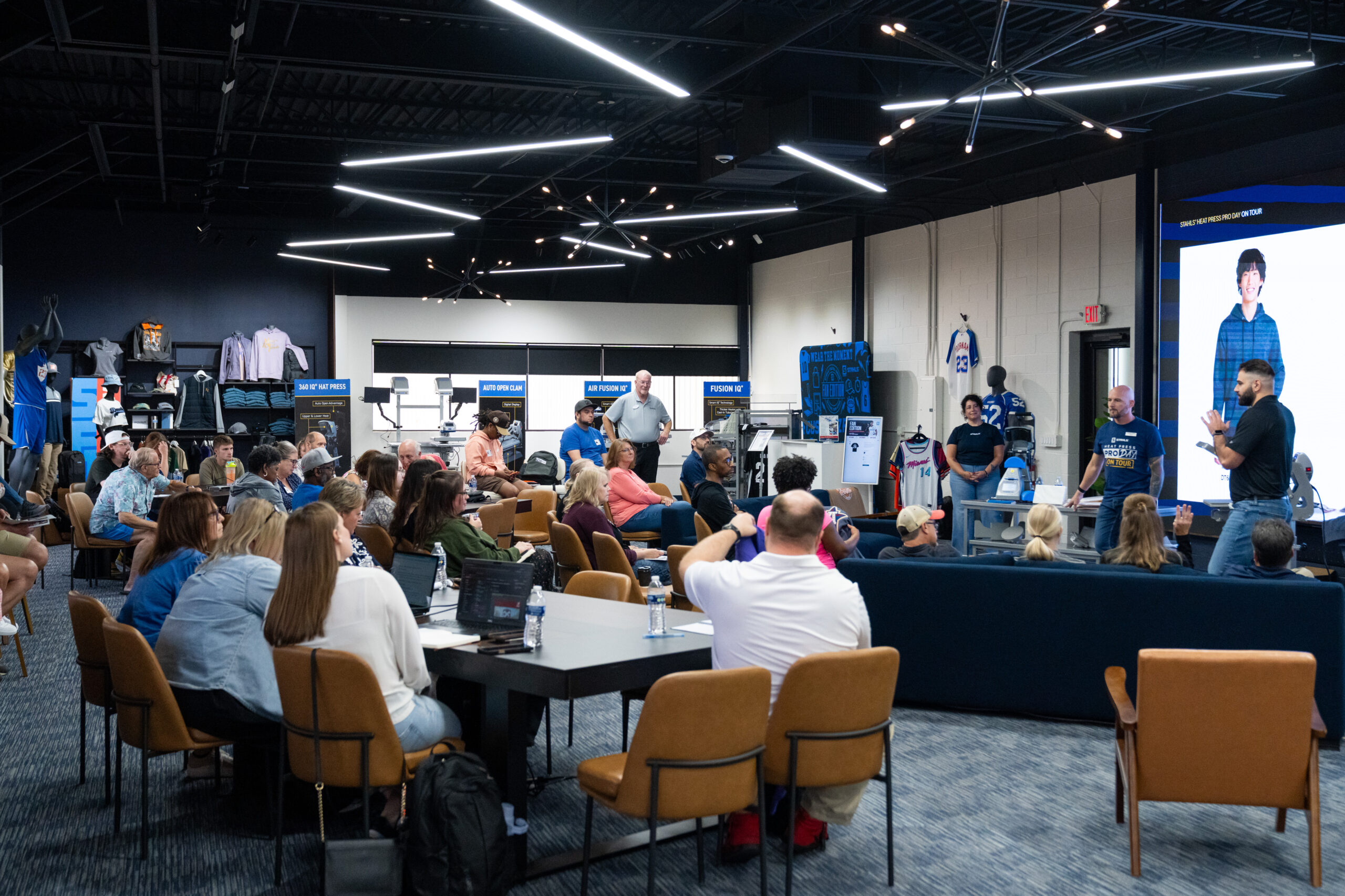 Attendees watch a live demonstration during STAHLS' Pro Day at the SF-1 Innovation Center featuring heat-printing technology, DTF printing and apparel decoration education.