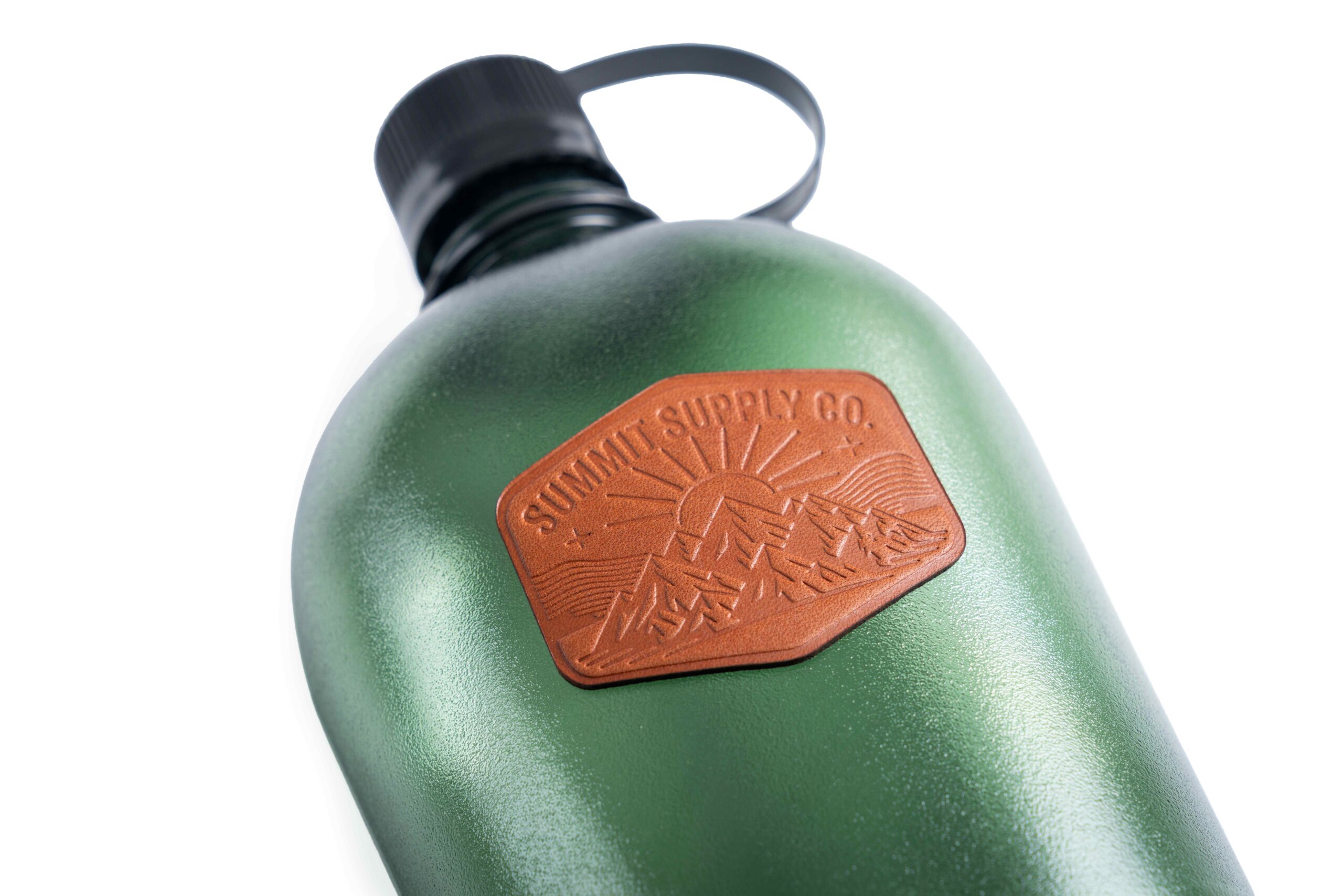 Debossed genuine leather patch applied to a green insulated bottle, showcasing STAHLS' premium leather patch for apparel, headwear and hard goods decoration
