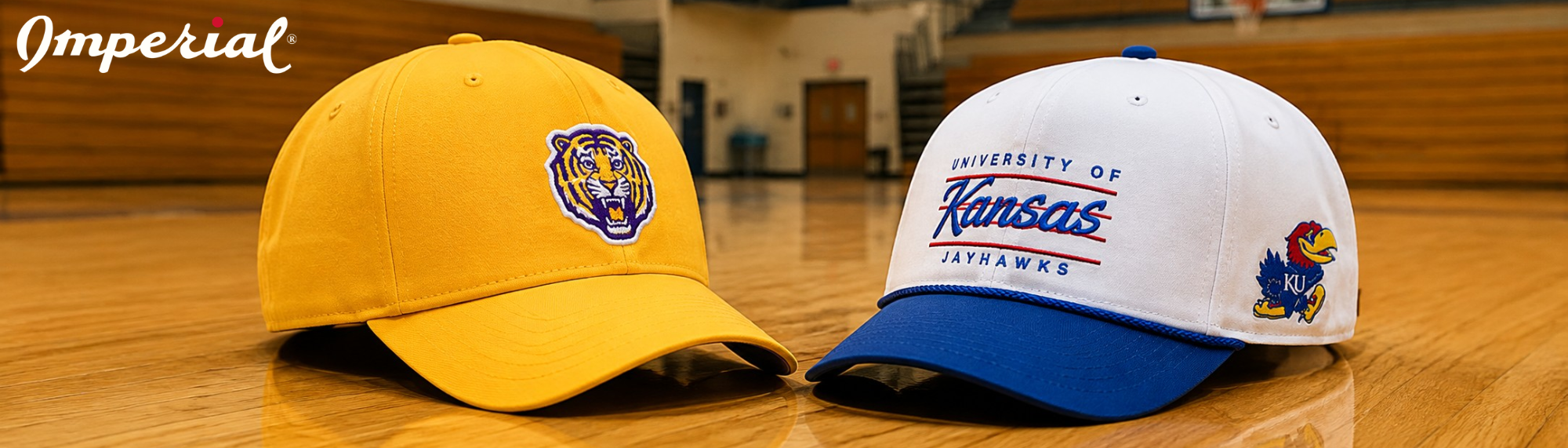Imperial College Collection embroidered collegiate caps featuring LSU Tigers and University of Kansas Jayhawks logos displayed on a basketball court
