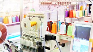 Embroidery machine, thread in a well organized custom embroidery shop