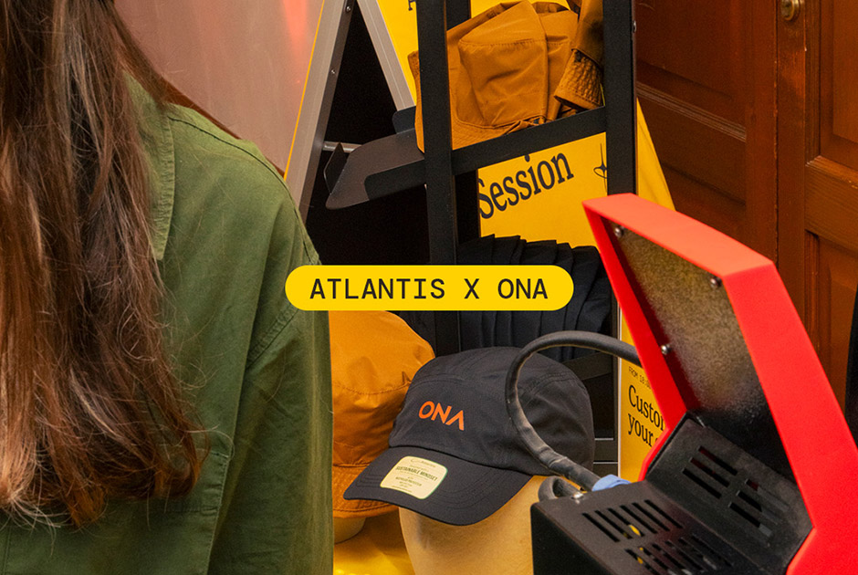 Black Atlantis Headwear x ONA cap displayed beside heat-press equipment at the ONA Short Film Festival.